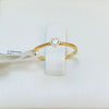 Gold ring with heart detail on a white box with product details.