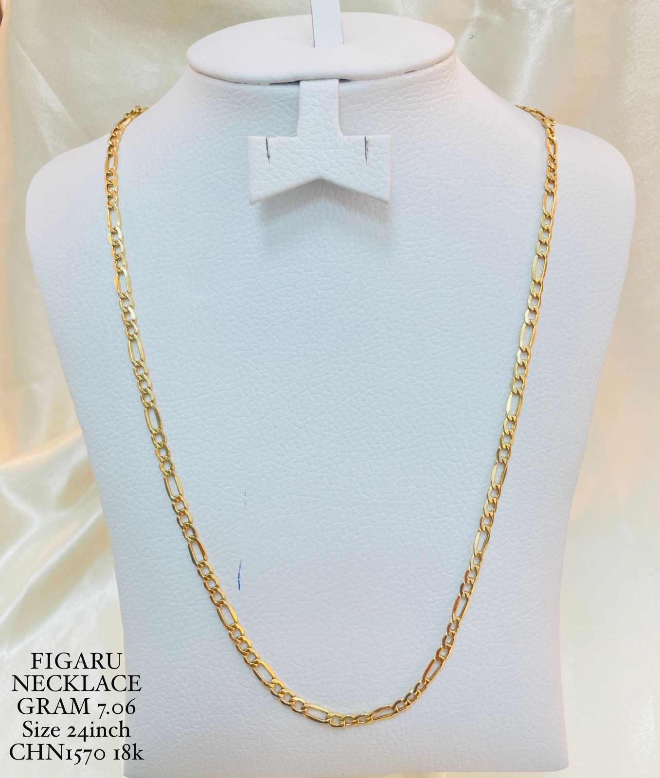 Gold necklace on a mannequin bust with product details.