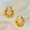 Pair of gold hoop earrings on a light fabric background