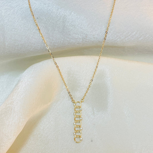 Gold chain necklace on a white fabric background