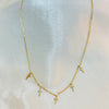 Gold necklace with small cross pendants on a white fabric background