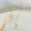 Gold necklace with a delicate pendant on a white fabric background