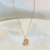 Gold necklace with a heart-shaped pendant on a white fabric background