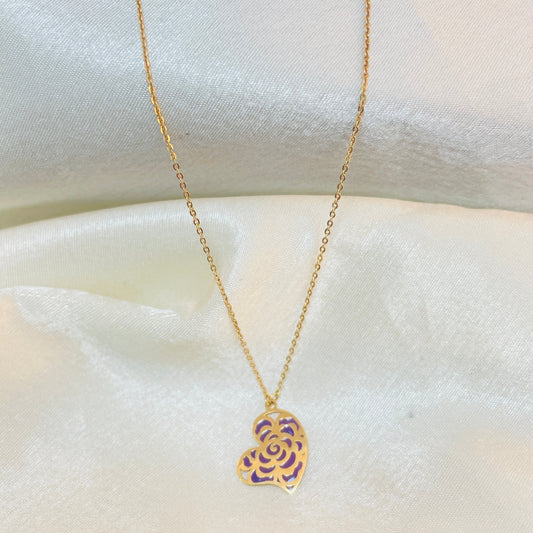 Gold necklace with a heart-shaped pendant on a white fabric background