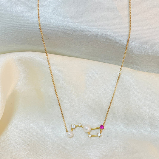 Gold necklace with star-shaped pendant on a white fabric background